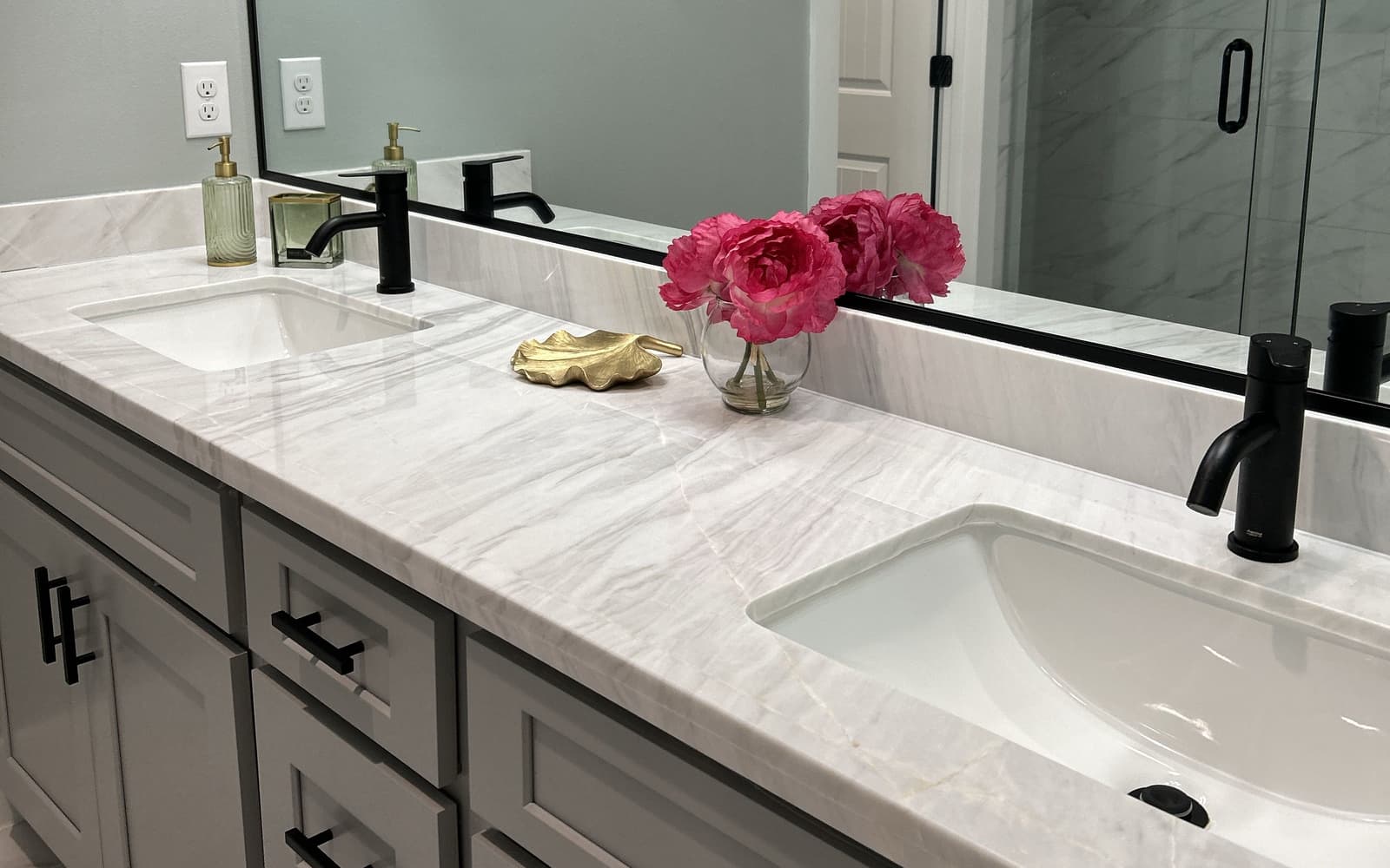 Spotless bathroom vanity with fresh flowers after a cleaning by YGB Cleaning Services in Houston, Texas